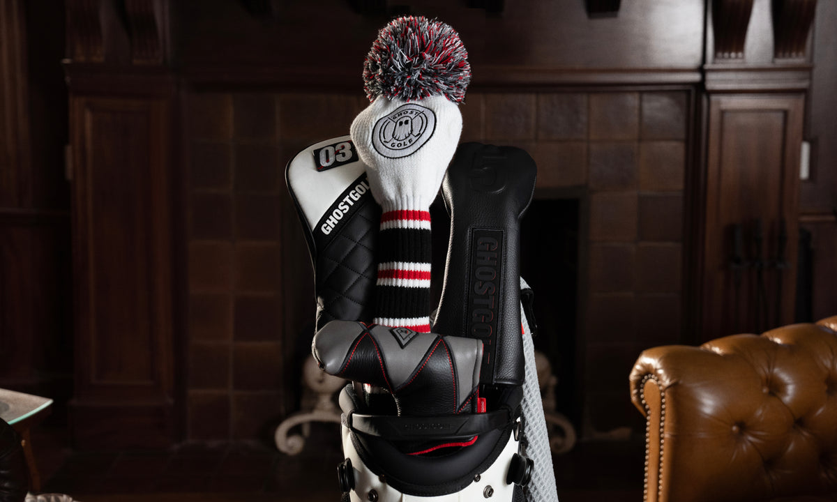 Lifestyle image of golf headcovers neatly placed on clubs in a golf bag, styled inside a vintage-inspired home.