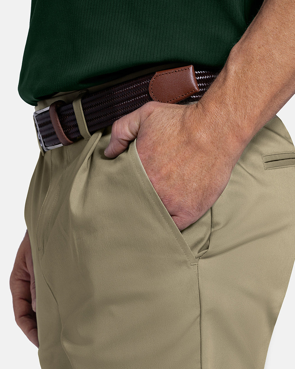 Closeup Side View of Sand Patrons Pleated Short on white male model with green polo tucked in wearing brown belt #color_sand