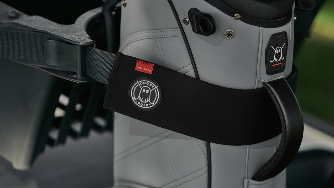 Grey Golf Bag on a Golf Cart with Black Ghost Golf Cart Strap Sleeve on it. 